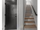 Modern staircase features light wood treads, white risers, black handrail, and sleek black door at 710 W North St # 103, Raleigh, NC 27603