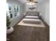 Staged bedroom with neutral tones, carpet flooring, and natural light streaming through the large windows at 720 Rawls Dr, Raleigh, NC 27610