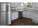 Modern kitchen featuring white cabinets, stainless steel appliances, granite countertops, and wood-look flooring at 720 Rawls Dr, Raleigh, NC 27610