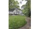 Well-maintained backyard with a lush green lawn, mature trees, and a patio perfect for outdoor entertaining and relaxation at 7517 Chippenham Ct, Raleigh, NC 27613