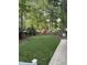 Lush backyard featuring a pristine lawn, mature trees, and a charming playset, creating an ideal space for recreation at 7517 Chippenham Ct, Raleigh, NC 27613