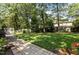 Backyard featuring lush lawn, mature trees, patio, and landscaping at 7517 Chippenham Ct, Raleigh, NC 27613