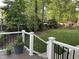 Inviting backyard view from the deck, showcasing a lush lawn, mature trees, and a fun playset for children at 7517 Chippenham Ct, Raleigh, NC 27613