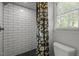 Bathroom featuring white subway tile shower, window, and floral shower curtain at 7517 Chippenham Ct, Raleigh, NC 27613