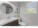 Well-lit bathroom with updated vanity, fixtures, and a round mirror at 7517 Chippenham Ct, Raleigh, NC 27613
