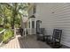 Wooden deck with rocking chairs overlooking a lush backyard with trees, plants, and a paved walkway at 7517 Chippenham Ct, Raleigh, NC 27613