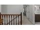 Hallway landing featuring wood railing, hallway closet, and bathroom/bedroom entrances at 7517 Chippenham Ct, Raleigh, NC 27613