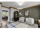 Well-appointed sitting room with a bar area, green accent wall, and hardwood flooring at 7517 Chippenham Ct, Raleigh, NC 27613