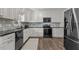 Modern kitchen with stainless steel appliances, granite counters, and custom backsplash at 7517 Chippenham Ct, Raleigh, NC 27613