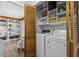 Convenient laundry room with washer, dryer, storage shelves, and folding doors at 7517 Chippenham Ct, Raleigh, NC 27613
