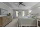 Spacious bedroom featuring neutral paint, soft carpet, ceiling fan, and multiple windows for natural light at 7517 Chippenham Ct, Raleigh, NC 27613