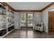Bright sitting area with built-in bookshelves, French doors, and a comfortable armchair for relaxation at 7517 Chippenham Ct, Raleigh, NC 27613