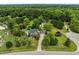 Aerial view of home featuring a pool, long driveway, and surrounded by lush trees at 7621 Troy Stone Dr, Fuquay Varina, NC 27526