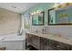 This primary bathroom includes a soaking tub, double vanity with dark cabinets, and great lighting at 7621 Troy Stone Dr, Fuquay Varina, NC 27526