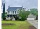 Charming two-story home with a covered porch, manicured lawn, and attached two-car garage at 7621 Troy Stone Dr, Fuquay Varina, NC 27526