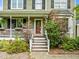 Close-up of the front steps and porch, featuring a bright red door and trimmed landscaping at 7621 Troy Stone Dr, Fuquay Varina, NC 27526