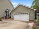 A detached garage with a white door is accessible from a concrete driveway in the side yard at 7621 Troy Stone Dr, Fuquay Varina, NC 27526