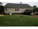 Rear exterior featuring well-kept lawn, a wooden deck, and access stairs at 780 Pondview Ct, Rocky Mount, NC 27804