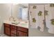 Bathroom showcasing double sinks with wood cabinets, decorated towels, and a large mirror at 82 Idlewood Ln, Clayton, NC 27527