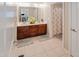 Bathroom with double sinks, decorative mirrors, and neutral tile flooring at 82 Idlewood Ln, Clayton, NC 27527