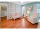 Cozy Bedroom with floral wallpaper, a crib, and a comfortable rocking chair at 82 Idlewood Ln, Clayton, NC 27527