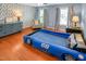 Playful bedroom featuring a race car bed, wood floors, and blue wallpaper at 82 Idlewood Ln, Clayton, NC 27527