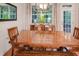 Wood dining table and bench set is framed by large windows and a view of the back yard at 82 Idlewood Ln, Clayton, NC 27527