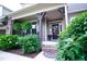 Welcoming front porch featuring hanging plants, lush flower bushes, and colorful decorations near the entrance at 82 Idlewood Ln, Clayton, NC 27527