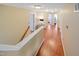 Upstairs hallway with wood floors featuring bright, natural lighting and several doorways at 82 Idlewood Ln, Clayton, NC 27527