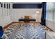 Stylish office with a navy accent wall, built-in shelving, modern desk, and eye-catching patterned rug at 82 Idlewood Ln, Clayton, NC 27527