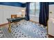 Bright office features a blue accent wall, contemporary desk with gold legs, and elegant window treatments at 82 Idlewood Ln, Clayton, NC 27527