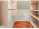 Spacious walk-in closet with wooden floors, custom shelving, and a convenient storage door at 82 Idlewood Ln, Clayton, NC 27527