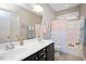 Bright bathroom featuring a double sink vanity, tiled floors, and a shower-tub with neutral color and decor at 821 Laurel Garden Way, Cary, NC 27513