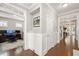 Inviting hallway with wainscoting and wood floors leading to a home office at 821 Laurel Garden Way, Cary, NC 27513