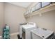 Well-organized laundry room with washer, dryer, sink, and shelving for ample storage at 821 Laurel Garden Way, Cary, NC 27513