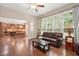 Open living room with wood floors, a fireplace, and access to the kitchen at 821 Laurel Garden Way, Cary, NC 27513