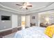 Spacious main bedroom with tray ceiling, TV, and ensuite bathroom access at 821 Laurel Garden Way, Cary, NC 27513
