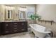 Elegant bathroom with a soaking tub, double vanity, stylish mirrors, and a window with a view at 8437 Charlie Stovall Rd, Oxford, NC 27565