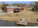 A lake and dock view in the backyard with a cozy red building at 8437 Charlie Stovall Rd, Oxford, NC 27565