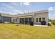 View of the gray home exterior with a spacious lawn, screened-in porch, and a concrete patio at 901 Del Webb Manor Ave, Wake Forest, NC 27587
