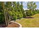 Lush garden featuring landscaping and mature trees, edged with stone and mulch at 901 Del Webb Manor Ave, Wake Forest, NC 27587