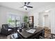 Home office with a ceiling fan, large windows, and a sophisticated wood desk and leather seating at 901 Del Webb Manor Ave, Wake Forest, NC 27587