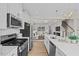 Open concept kitchen with stainless appliances, quartz counters and view to living area at 910 Kensley Grove Ln # 70, Fuquay Varina, NC 27526