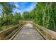 Wooden walking bridge stretching over a nature area and tree-lined surroundings at 910 Kensley Grove Ln # 70, Fuquay Varina, NC 27526