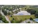 Overhead view of a community lake with dam, trees, tennis court, parking and surrounding neighborhood at 1004 Taywood Way, Apex, NC 27502