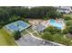 Aerial view showcases community amenities like a swimming pool, playground, and tennis courts surrounded by lush greenery at 1004 Taywood Way, Apex, NC 27502