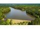 Scenic aerial view of a lake with a dam surrounded by lush, green forests and walking trails at 1004 Taywood Way, Apex, NC 27502
