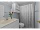 Cozy bathroom with a single sink, white cabinets, and a shower-tub combo with a patterned curtain at 1004 Taywood Way, Apex, NC 27502