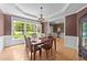 Elegant dining room with a chandelier, large windows, and a formal dining table set for a meal at 1004 Taywood Way, Apex, NC 27502