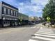 Downtown street featuring businesses, pedestrian crosswalks, and parked vehicles, representing a vibrant community at 1004 Taywood Way, Apex, NC 27502